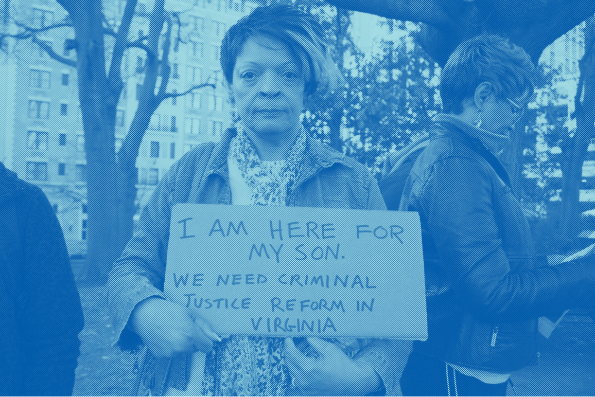 a woman holding a sign that says "I am here for my son. We need criminal justice reform in Virginia"