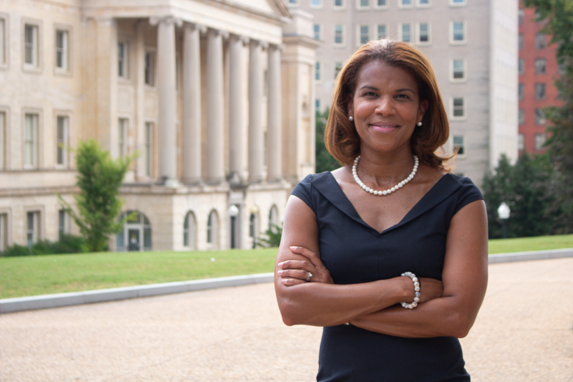 Kemba Smith standing in front of a court house with her arms folded in front of her chest