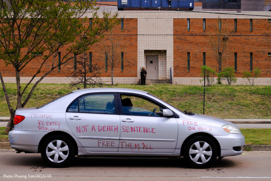 a silver car with red writings that say "not a death sentence" "free them all" "free our youth" and so on