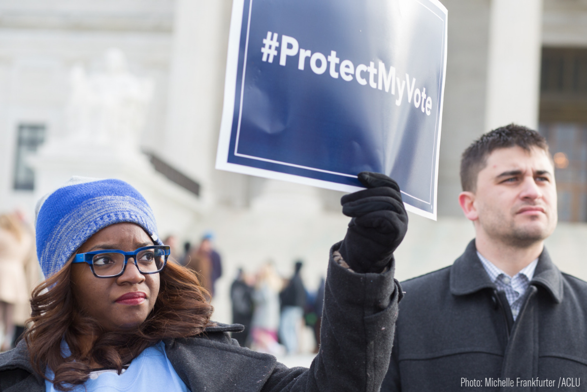 A Black woman holding a sign that says "Protect My Vote"