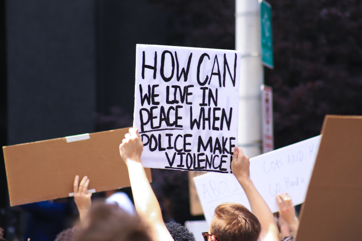 a protest sign with the text "how can we live in peace when police makes violence"