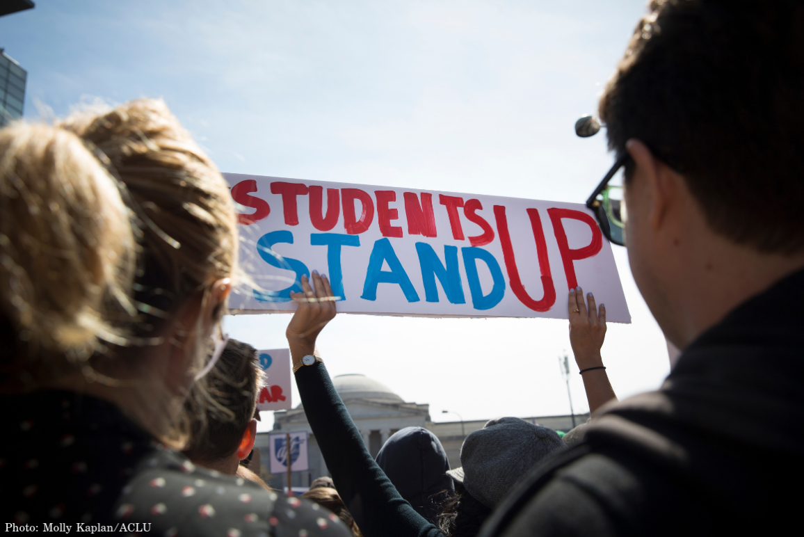 A student held a sign saying "Students Stand Up" in red and blue at the March for Our Lives in 2018