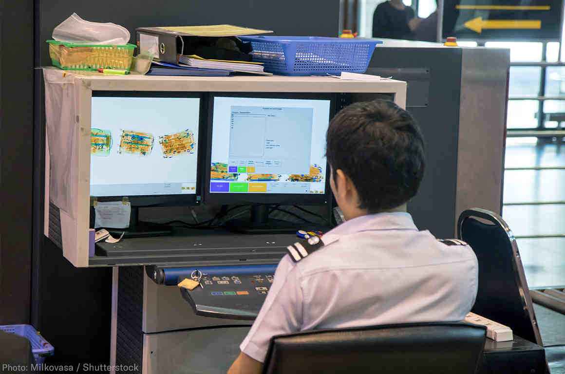 A customs agent looking at airport security monitor