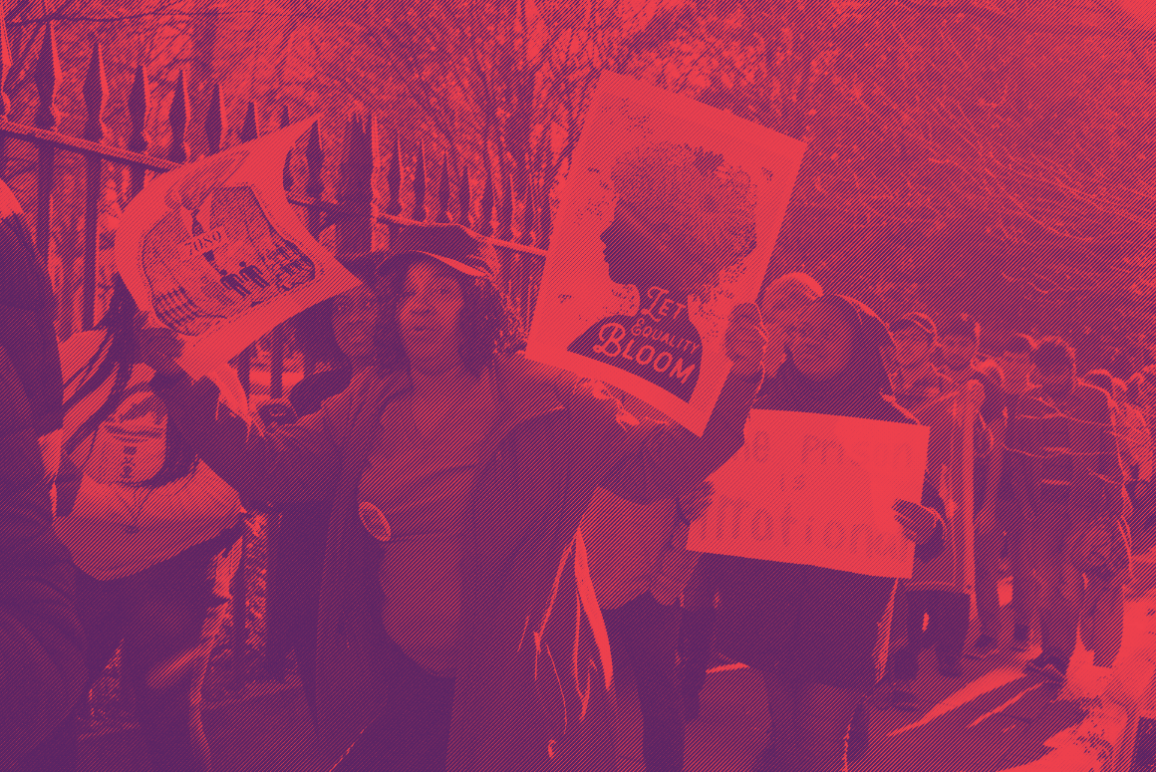 Protesters holding a sign that says "Let Equality Bloom"