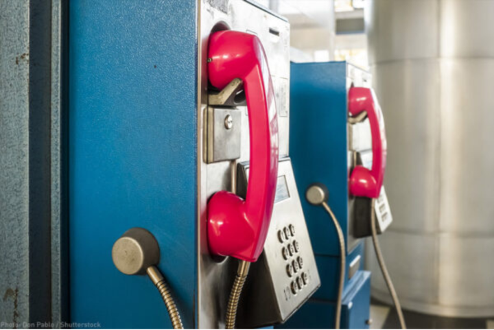 pay phone booths in prison with red phone over blue booth.