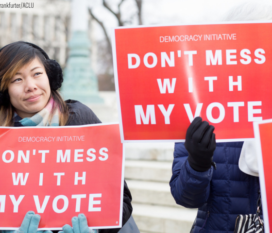 A woman holding a red sign with white text that says "Don't Mess With My Vote"