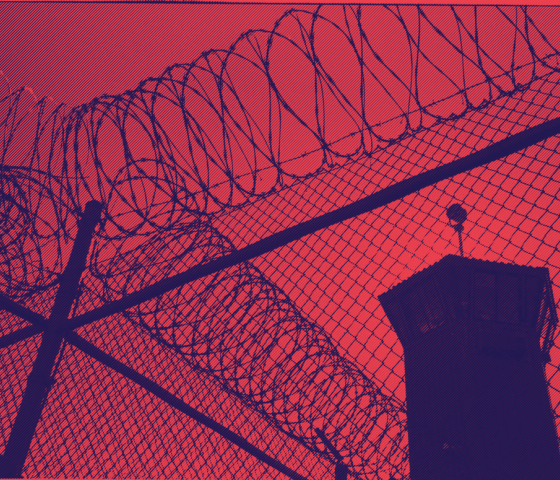 a picture of barbed wire and a prison watch tower